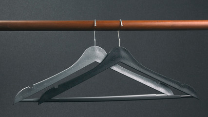 Empty gray plastic clothes hanger hanging on a dark background. Accessories and items for storing...