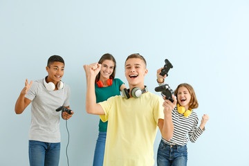 Obraz premium Teenager boy with friends playing video games against light background