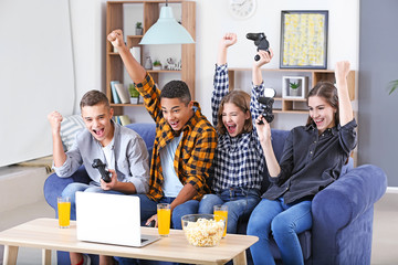 Teenagers playing video games at home