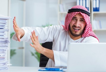 Arab businessman working in the office doing paperwork with a pi