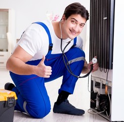 Repairman contractor repairing fridge in DIY concept