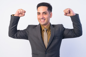 Portrait of happy Persian businessman in suit flexing both arms