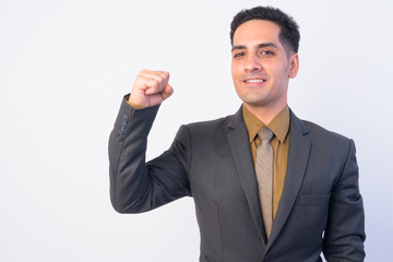 Portrait of happy Persian businessman in suit with fist raised