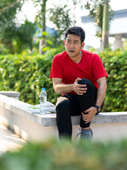 Asian sport man in red t-shirt hurts his leg with accident.