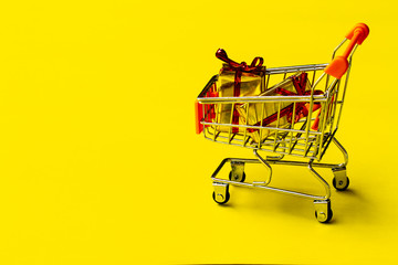 shopping cart toy with on  yellow background.