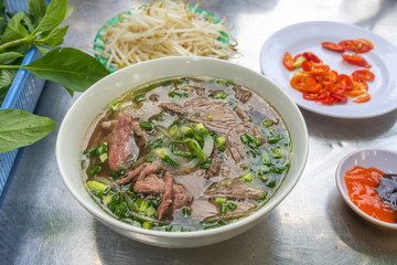 Pho beef noodles soup served with vegetables and bean sprouts