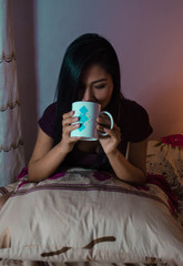 mujer en la cama tomando te cafe con taza