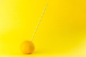 orange with yellow paper straw isolated  on a orange colored background 