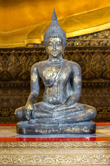 an ancient Black sitting Buddha statue in Wat Pho church.