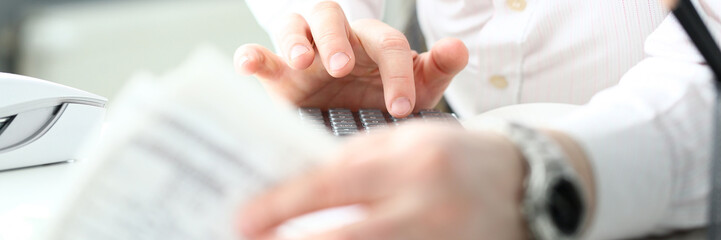 Male clerk finger pressing buttons on calculator devise evaluating expenses