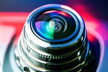 Fototapeta na wymiar The camera lens with red and blue backlight. Optics.