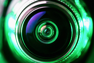 The camera lens and green backlighting. Green camera Lens close Up. Gorizontal photo