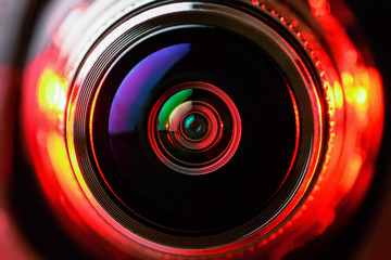 The camera lens and the beautiful light red color. Horizontal photo