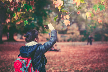 Woman taking photos in Hyde Park in fall season