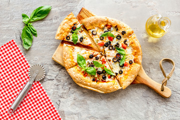 Pizza with tomato, basil, olives, cheese on grey background top view