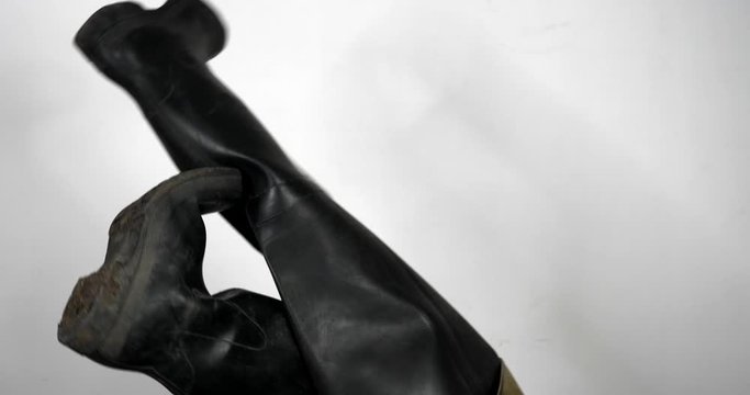 Person trying to take off rain boots with sexy net tights in studio,close up shot