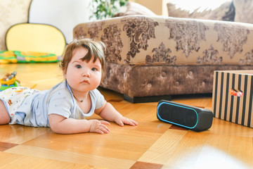 the child listens to a portable speaker system. listening to music from an early age