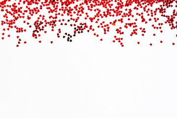 Valentine's Day background - a frame of scattered heart shaped confetti over white background.