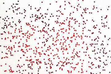 Valentine's Day background - scattered heart shaped confetti over white background.