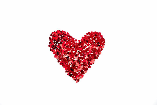 Valentine's Day concept - heart shaped confetti arranged like heart over white background.