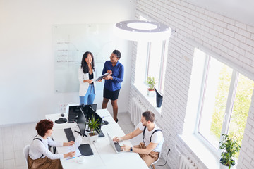 Obraz premium Business for people. Young staff having conversation with african coach, businesswoman, Smiling, laughing