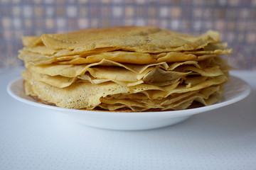 Thin fried pancakes on a white plate