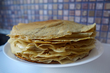 Thin crispy pancakes on a white plate