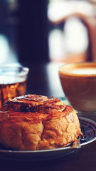 Sweet bakery and hot coffee on wooden coffee table in cafeteria, vintage color   tone process and selective focus for business food and drink background