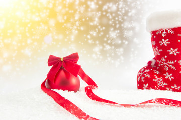 Christmas red ball with ribbon on snow