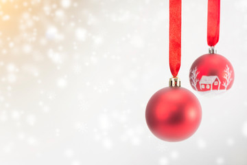 Two Christmas red balls with ribbon on snow