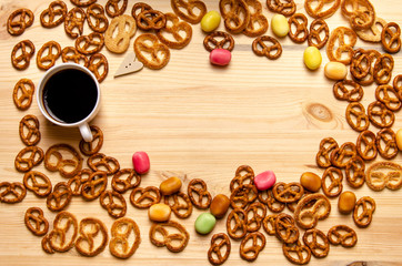 Coffee cup, candies and cookies, wooden surface