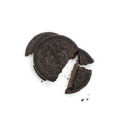Broken black cookie sandwich. Close up. Isolated on white background