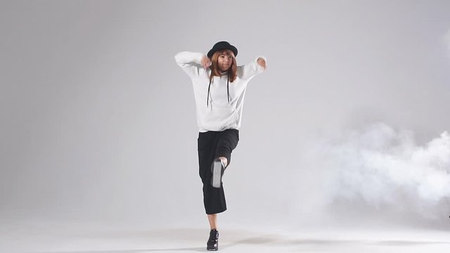 Flexible young dancer doing split leap in the air, raising leg intensively up, standing on one leg, enjoying dancing, athletic modern style dance