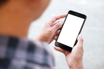 Cropped shot view of man hands holding smart phone with blank copy space screen for your text message or information content, female reading text message on cell telephone during in urban setting. 