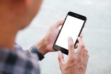 Cropped shot view of man hands holding smart phone with blank copy space screen for your text message or information content, female reading text message on cell telephone during in urban setting. 