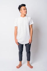 Full body shot of young Asian man thinking