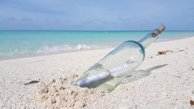 Bottle with a message plugged in the white sand on an exotic island in the Caribbean, Jamaica - Static close-up shot