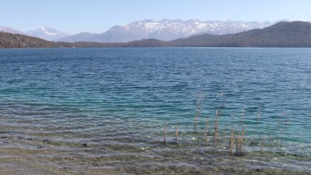 Timelapse of Rara lake with three different shades of color with snow-clad mountains in the background. Wide shot.