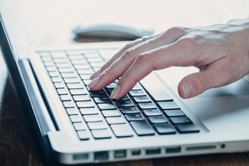 Woman working at home office hand on keyboard close up