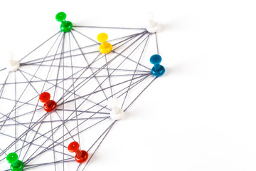 Network with colorful pins and string,  linked together with string on a white background suggesting a network of connections.