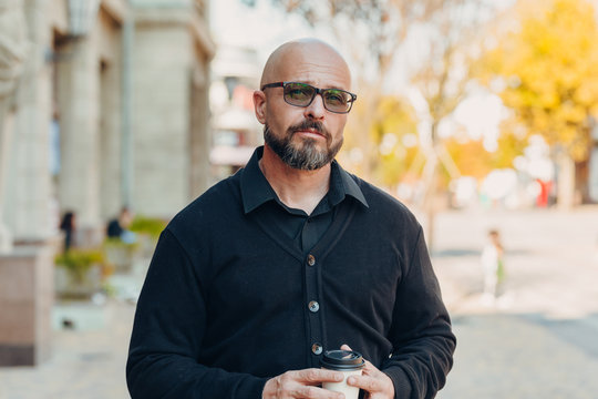 Outdoor Portrait Of A 50 Year Old Happy Man Wearing A Black Shirt And Glasses