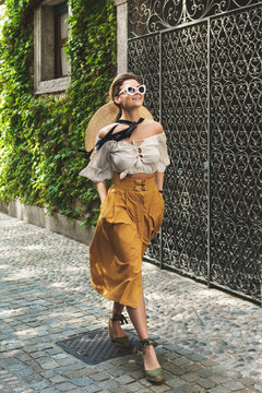 Fototapeta Young woman walking by the streets of small Italian town
