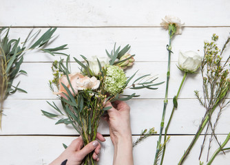 Workshop florist, making bouquets and flower arrangements. Woman collecting a bouquet of flowers.