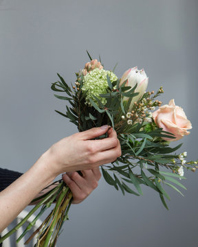 Workshop florist, making bouquets and flower arrangements. Woman collecting a bouquet of flowers.