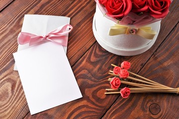 Gift box with flowers on wooden background, preparation for the holiday concept. Top view and copy area for text.
