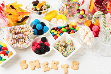 Many different colorful unhealthy sweet candies. Mix desserts for holiday. Sweet table for Birthday