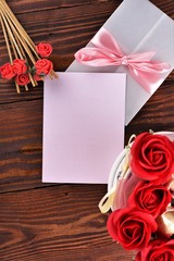 Gift box with flowers on wooden background, preparation for the holiday concept. Top view and copy area for text.