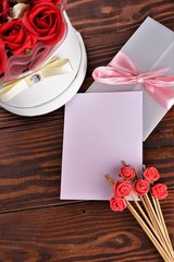 Gift box with flowers on wooden background, preparation for the holiday concept. Top view and copy area for text.