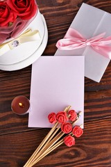 Gift box with flowers on wooden background, preparation for the holiday concept. Top view and copy area for text.