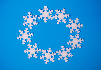 Christmas or winter frame. Circle snowflakes on a blue background. Flat lay, top view, space for text.